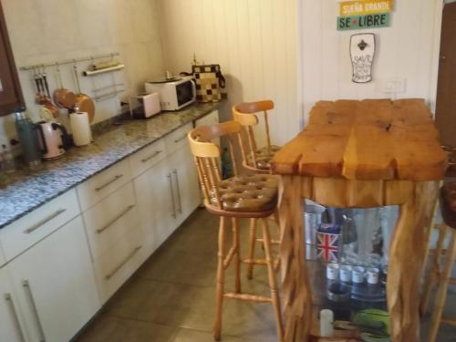 cocina con mesa de madera y 2 sillas en Reina Mora, Reserva Patagonica en San Martín de los Andes