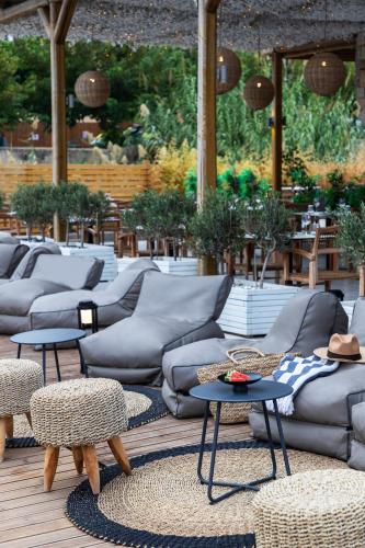 a group of couches and tables on a patio at Eden Roc Resort - All Inclusive in Kallithea Rhodes