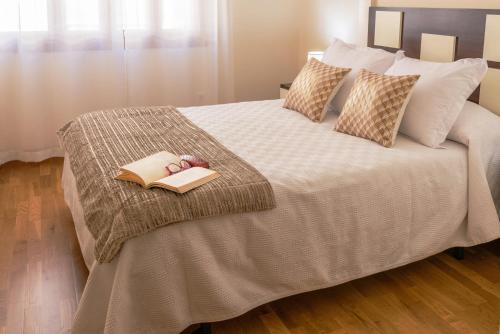 a bedroom with a bed with a book and pair of shoes at apartamento centro sanxenxo con parking gratis in Sanxenxo