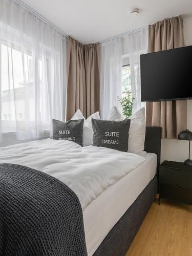 a white bed with two pillows on top of it at Limehome Passau Bahnhofstraße in Passau