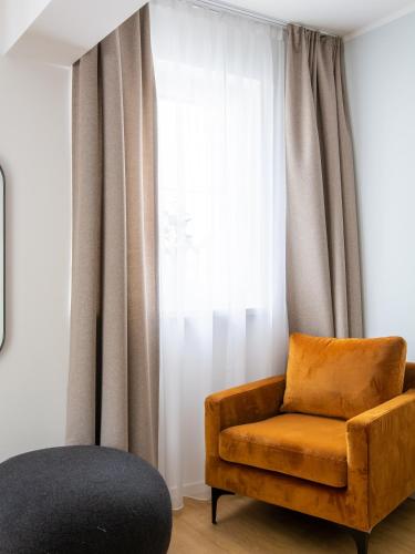 a living room with a chair and a window at Limehome Passau Bahnhofstraße in Passau