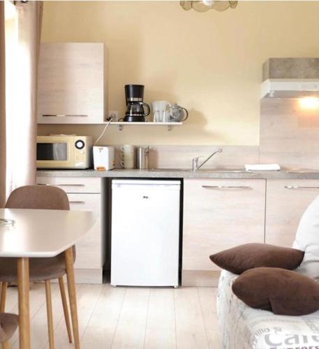 Il comprend une cuisine équipée d'un réfrigérateur blanc et d'une table. dans l'établissement Studio vue Tourmalet dans villa historique "Victoria", à Argelès-Gazost