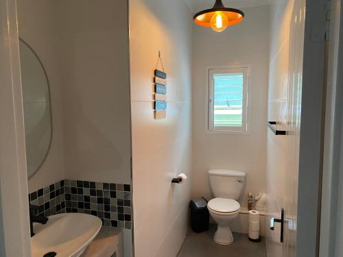 a bathroom with a white toilet and a sink at Ballito Durban north Aloha in Ballito