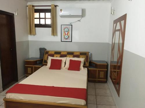 a bedroom with a bed with red pillows at Hotel City I in Santo André