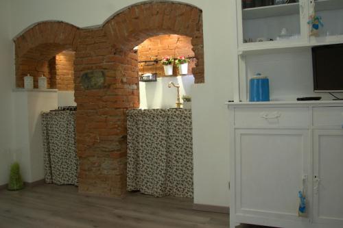 a room with a brick wall and an archway at La Finestra sul Borgo in Campo Ligure