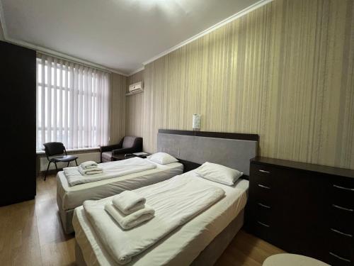 a hotel room with two beds and a chair at The apartments in Kyiv