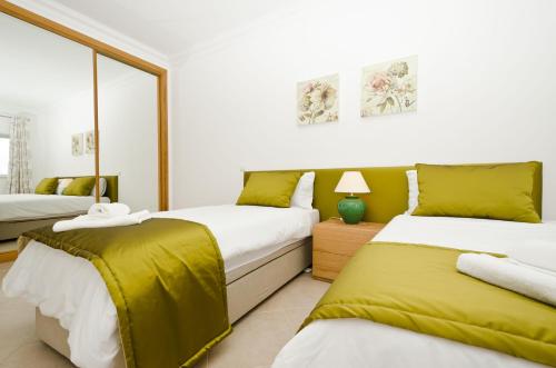 1 dormitorio con 2 camas con sábanas amarillas en Fairviews Villa on Boavista Golf Resort, en Lagos