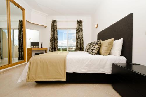 1 dormitorio con 1 cama grande y ventana grande en Fairviews Villa on Boavista Golf Resort, en Lagos