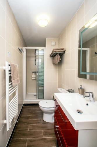 a bathroom with a toilet and a sink and a shower at The Originals Boutique, Hôtel de La Baie de Morlaix in Carantec