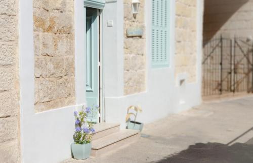a white house with a bench and flowers at Casa Bartolo A Hidden Gem - Spacious Village Home EBAR1-1 in Lija