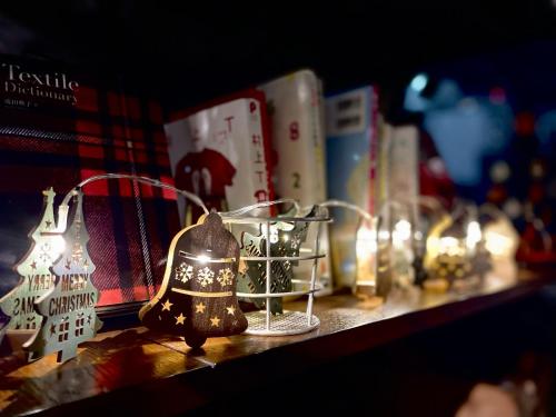 a shelf with christmas ornaments and books on it at hotel the textile in Gifu