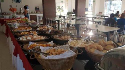 uma linha de buffet com muitos tipos diferentes de alimentos em Hotel Golden Dolphin com café da manhã! Piscinas 24h em Caldas Novas