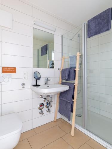a bathroom with a sink and a shower at Limehome Passau Bahnhofstraße in Passau