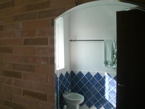 a bathroom with a toilet and a brick wall at I Ciliegi in Osimo