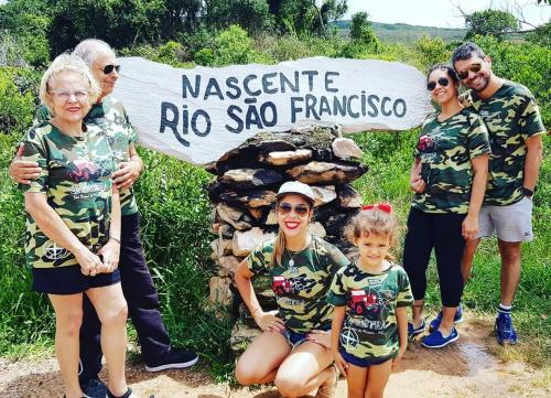 a group of people standing in front of a sign at Pousada e Camping Daniel in São Roque de Minas