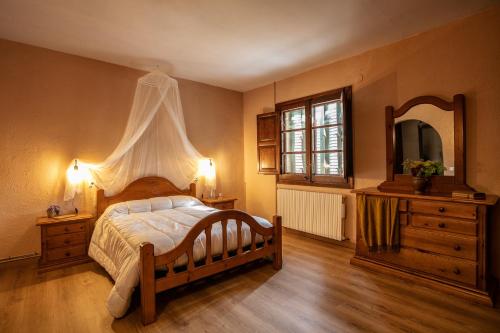 um quarto com uma cama, uma cómoda e um espelho em El Xalet del Priorat em Escaladei