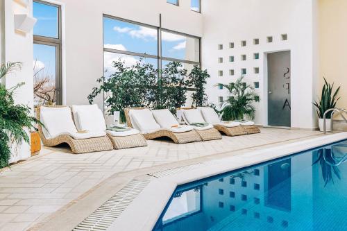 uma casa com piscina e espreguiçadeiras ao lado de um edifício em Delina Mountain Resort em Anogeia