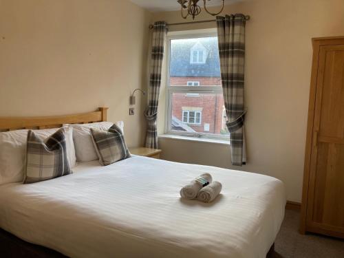 a bedroom with a bed with a stuffed animal on it at Pepper Street Rooms in Whitchurch