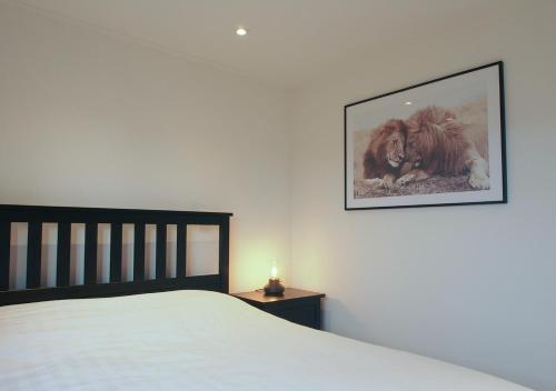 1 dormitorio con 1 cama y una foto en la pared en Chaletparc Krabbenkreek Zeeland - Chalet 80 en Sint Annaland