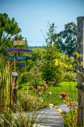 a wooden path in a garden with signs on it at Pod mazurskim niebem dom rustykalny in Piecki