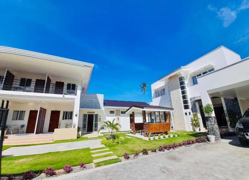 a white house with a car parked in the driveway at Maykenn Beach in Bantayan Island