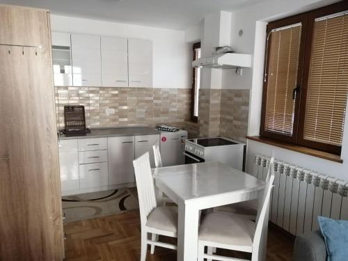 a small kitchen with a white table and chairs at Vila Meridijan in Zlatibor