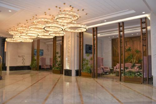 a lobby with a large chandelier in a building at Midan Hotel & Suites Al Aziziya in Makkah