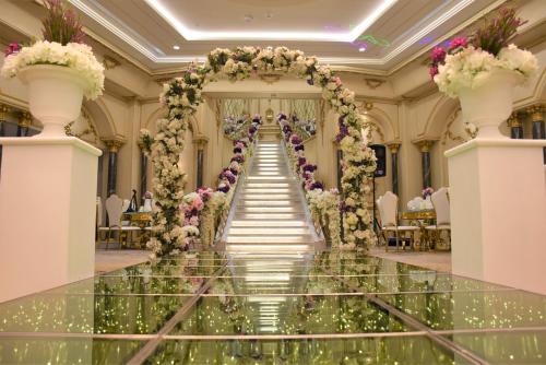 an aisle at a wedding in a building with flowers at Midan Hotel & Suites Al Aziziya in Makkah