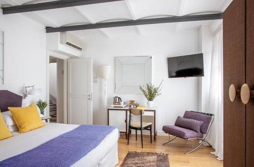 a bedroom with a bed and a desk and a tv at Locanda Rossa in Capalbio