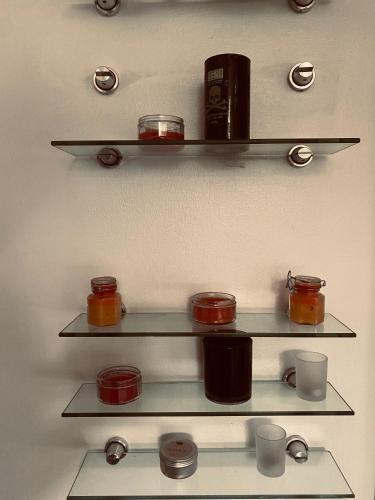 a shelf with jars and cups on it at Angel Hotel in Lagos