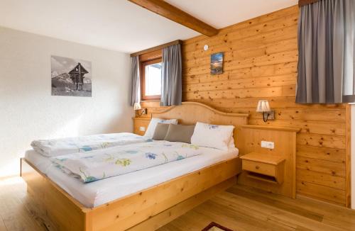 ein Schlafzimmer mit einem Bett in einer Holzwand in der Unterkunft Gästehaus Zugspitzblick in Berwang