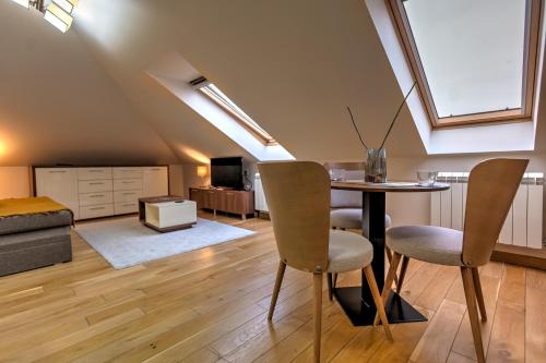 a attic living room with a table and chairs at Apartman 501 in Vračar (historical)