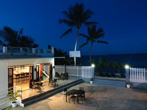 a house with a deck with tables and chairs at night at Maykenn Beach in Bantayan Island