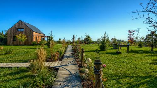 a garden path with a wooden fence and a barn at Pod mazurskim niebem dom rustykalny in Piecki