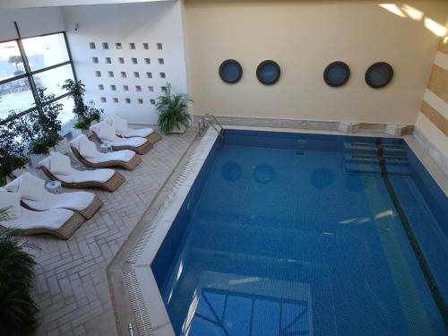 a swimming pool in a building with lounge chairs next to it at Delina Mountain Resort in Anogia