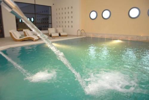 a pool with a water fountain in a building at Delina Mountain Resort in Anogia
