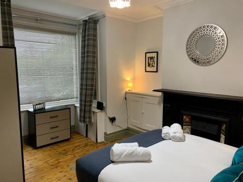 1 dormitorio con 1 cama, chimenea y ventana en Stamer House by YourStays, Stylish quirky house, with 4 double bedrooms, BOOK NOW!, en Stoke on Trent
