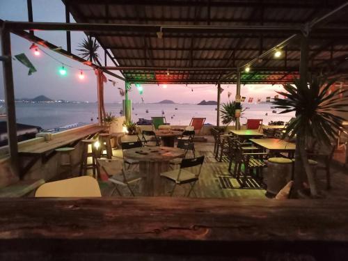 a restaurant on the beach with tables and chairs at Sattahiptale Boutique Guesthouse & Hostel in Sattahip