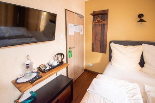 a bedroom with a bed and a tv on the wall at Boutique Hotel Sena in Berlin