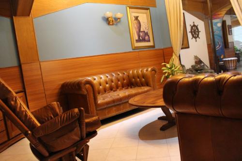 a living room with a leather couch and a table at Sunny Garden in Antananarivo
