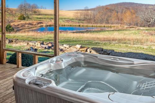 a bath tub on a deck with a view of a field at This is the ultimate in private escape in Ponca