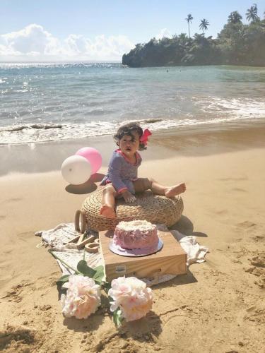 a baby sitting in a basket on the beach at Vista Mare Samana The Best View!! in Santa Bárbara de Samaná