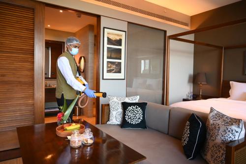 a man wearing a mask in a hotel room at Taj Chia Kutir Resort & Spa Darjeeling in Darjeeling