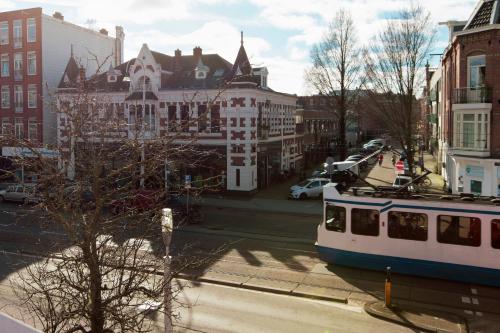 a tram on a street in a city with buildings at The Manor Amsterdam in Amsterdam