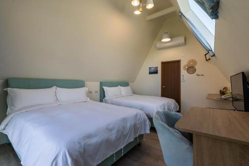 a room with two beds and a television in it at 花蓮晨風星語民宿Sun Star B&B in Jian
