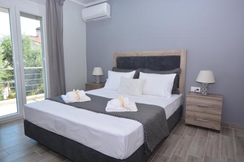 a bedroom with a large bed with two towels at Blue North Luxury Apartment in Limenas