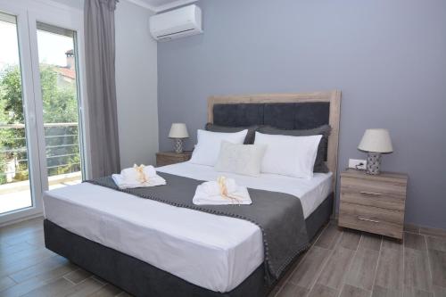 sypialnia z dużym łóżkiem i 2 ręcznikami w obiekcie Blue North Luxury Apartment w mieście Limenas