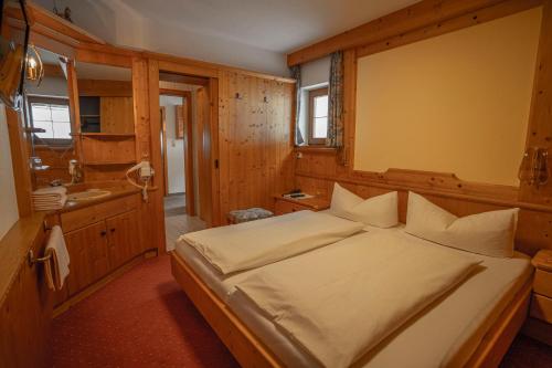 a bedroom with a bed and a bathroom with a sink at Gasthof Waldesruh in Oetz