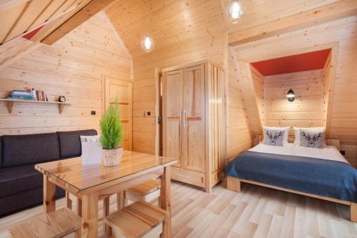a small bedroom with a bed and a table at Pokoje Gościnne BENITA in Zakopane
