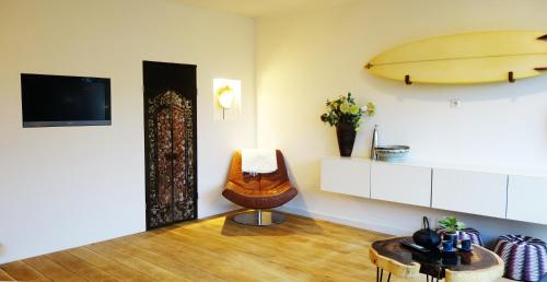 una habitación con una silla y una tabla de surf en la pared en Bali Beach, en Zandvoort